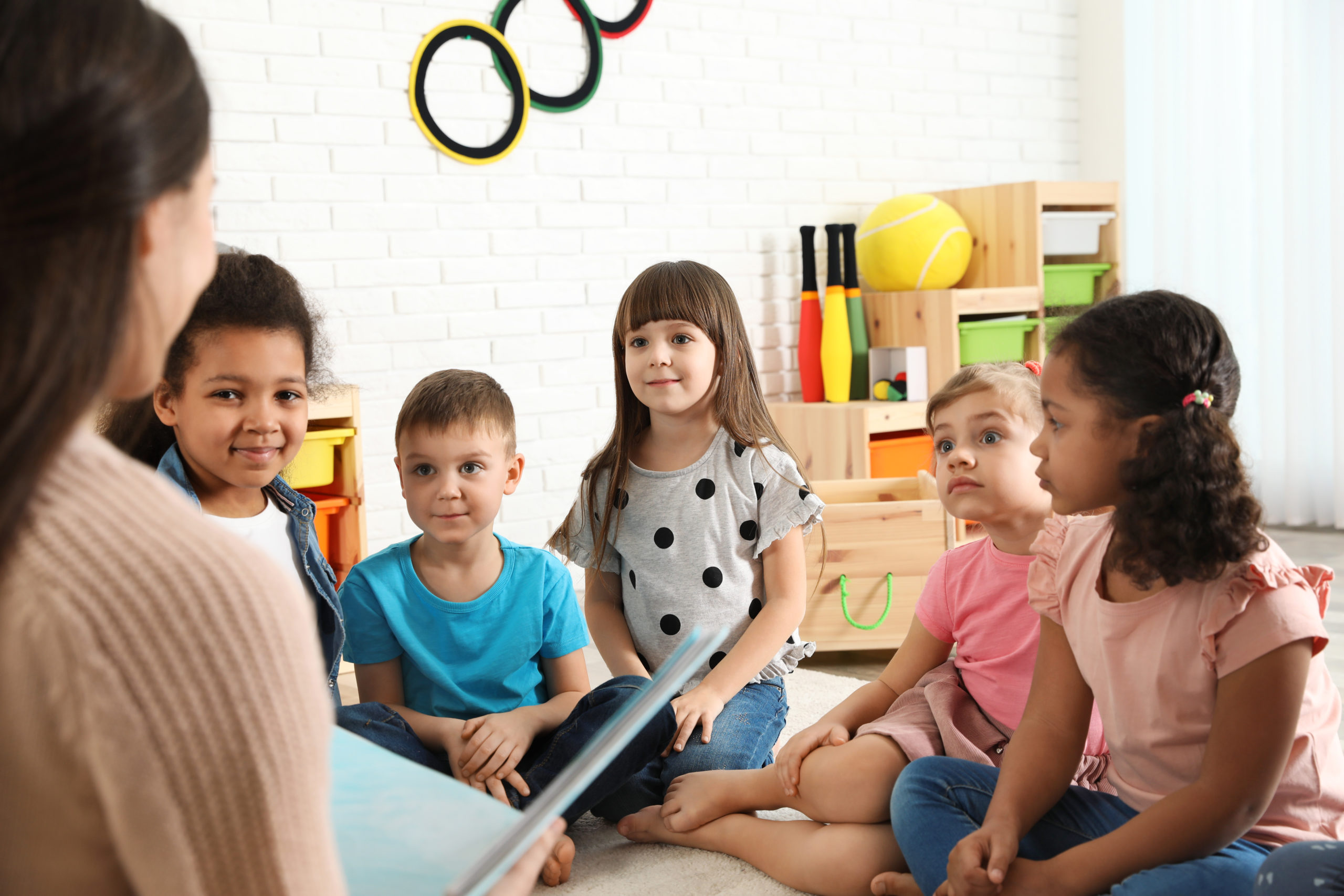 Children sitting and listening to a story at Premier Learning Center's preschool programs.